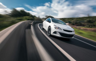 White Car Cornering In Mountain Road With Speed Blur | McCormick Insurance