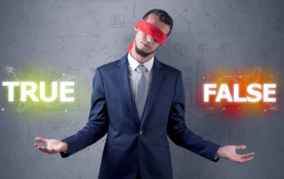 Businessman with red ribbon on his eye deciding true or false | McCormick Insurance Insurance Questions